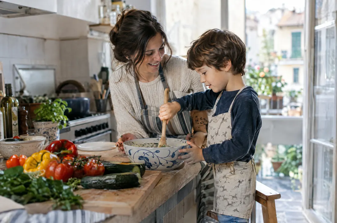 Una madre e il figlio di cinque anni cucinano insieme la cena in una cucina luminosa